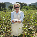 Woman in a field holding freshly picked cotton