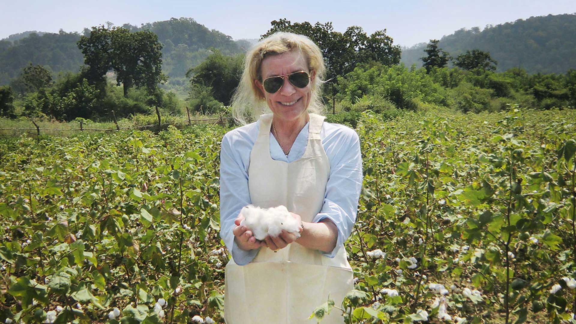 Woman in cotton field holding freshly picked cotton