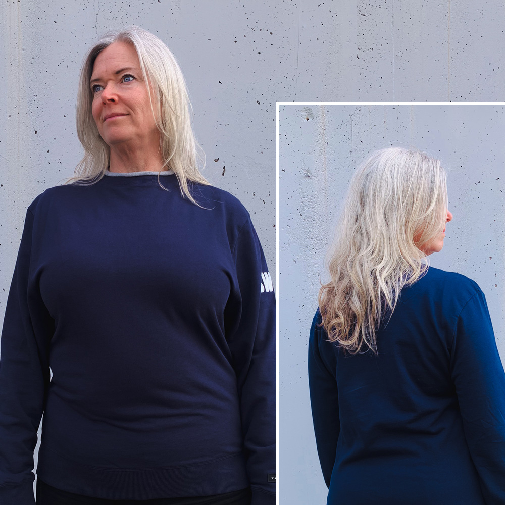 Woman wearing navy Volvo sweatshirt with SWE and Swedish flag on the sleeve