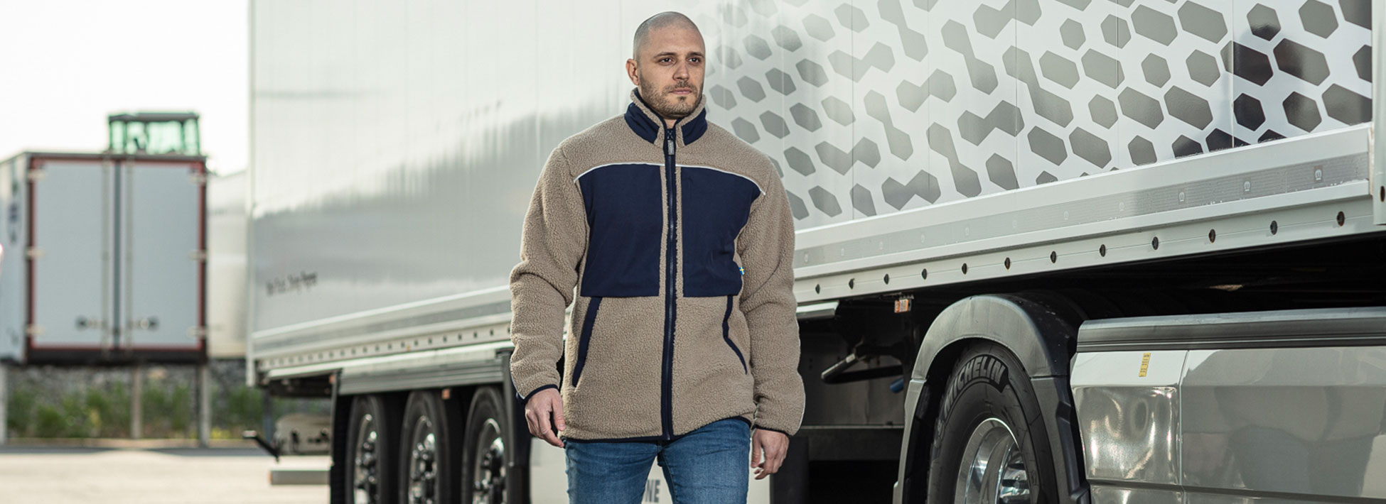 Male model wearing performance fleece jacket from Volvo merchandise in beige and navy.