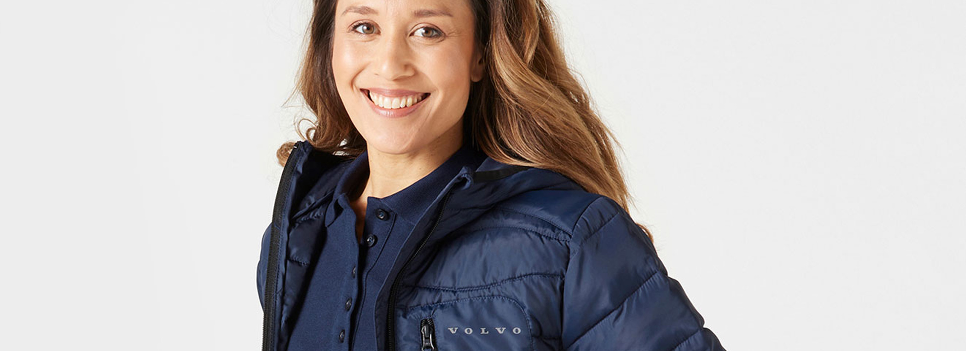 Woman wearing navy polo shirt and event jacket from Volvo Merchandise.