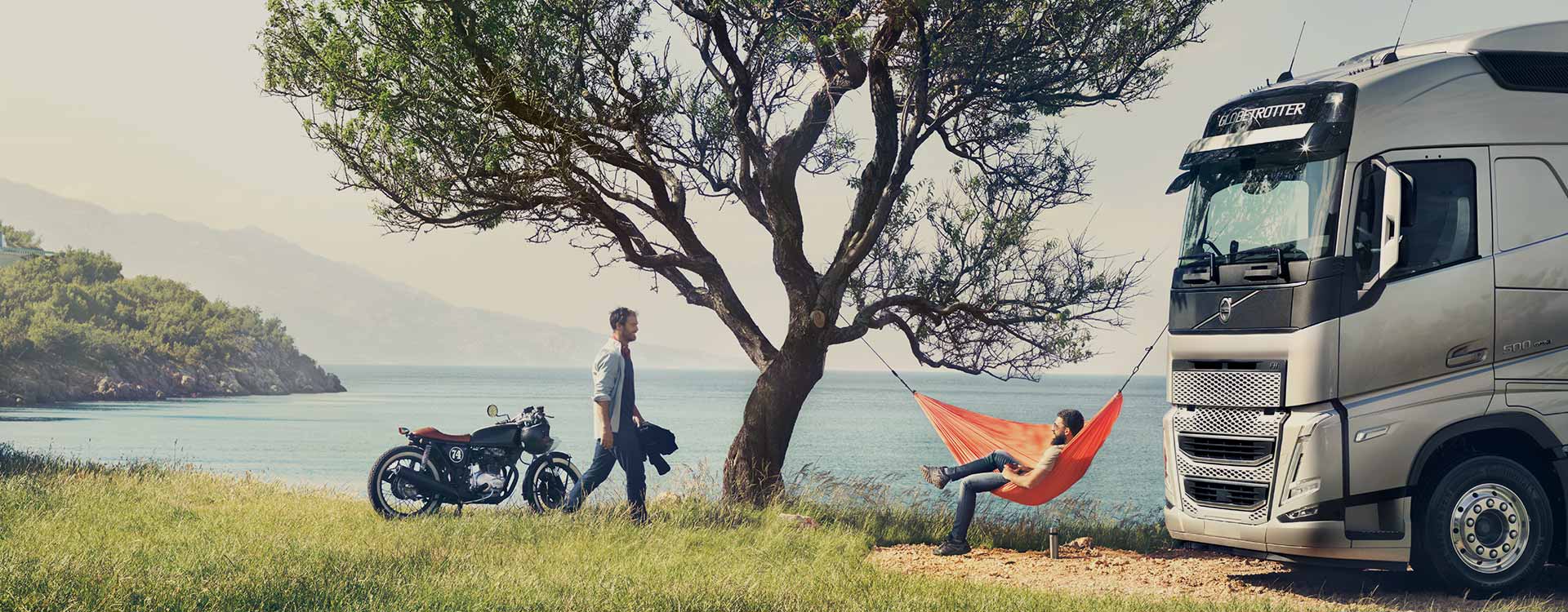 Two men in outdoor environment with truck and motorcycle	 horizontal image