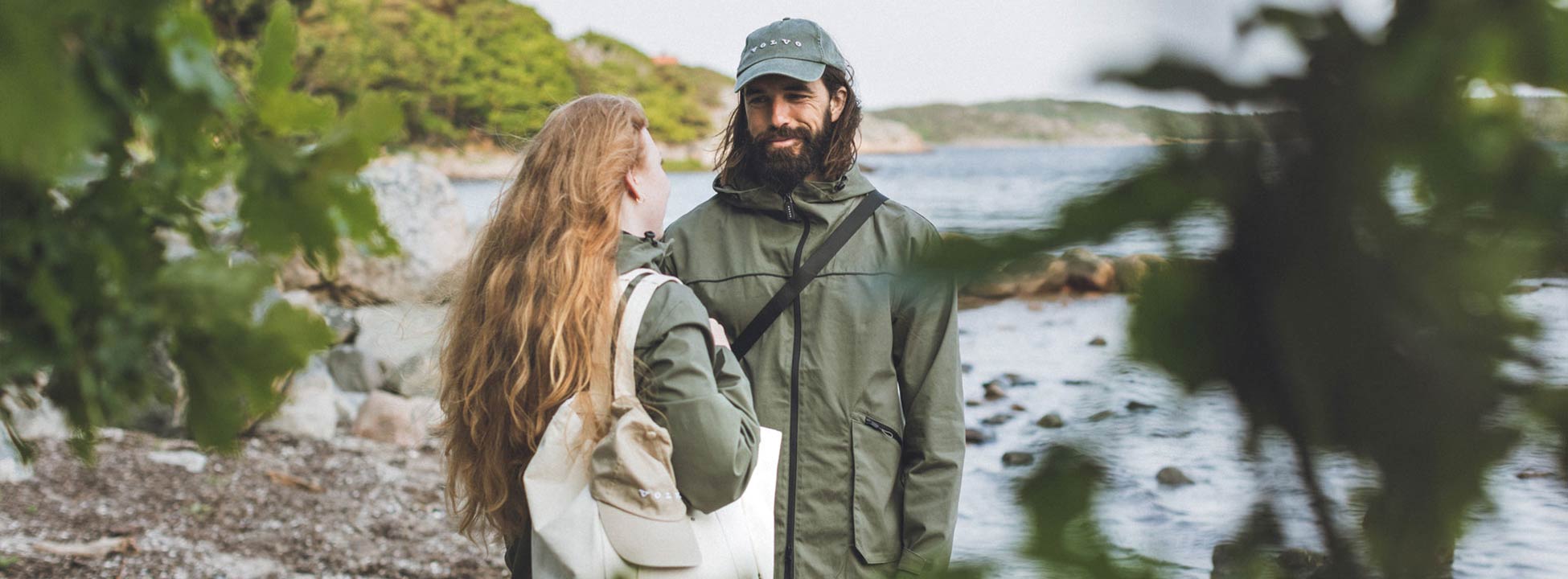 Woman and man wearing green Volvo cotton canvas jacket on beach